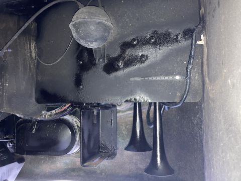 2015 Ford F-550 - Close-up view of air horns and an air tank, likely part of a truck's air brake system.