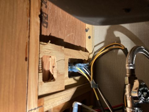 2015 Ford F-550 - Exposed wiring harness and plumbing fixture visible in a wooden compartment.