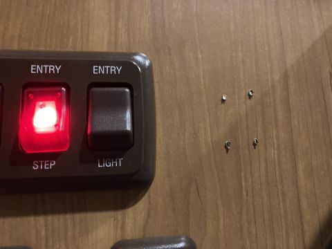 2015 Ford F-550 - Close-up of an interior control panel with illuminated switches and surrounding wood paneling.