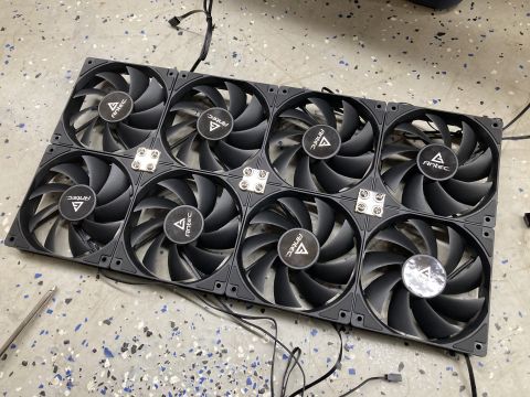 2015 Ford F-550 - Eight Antec computer case fans are laid out on a speckled floor, with wires visible.