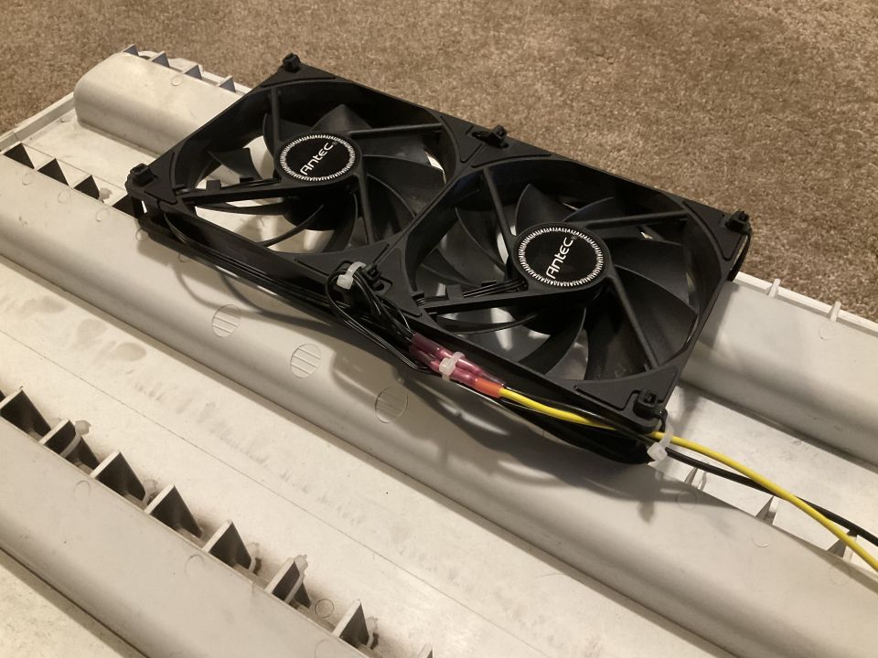 Two Antec computer fans attached to a white vent cover