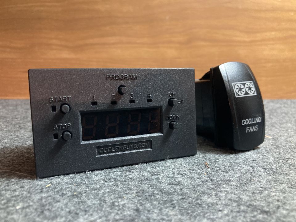 Black digital controller with 'COOLERGUYS.COM' and a black toggle switch labeled 'COOLING FANS' with fan icons