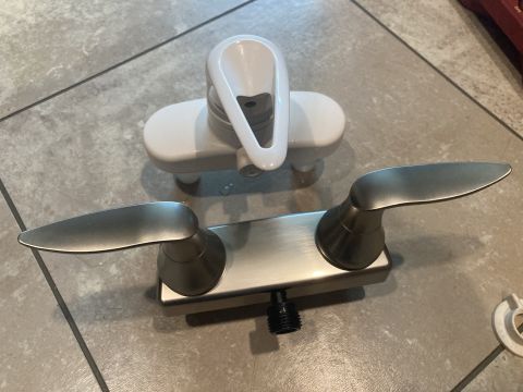 2015 Ford F-550 - Two shower faucet handles and diverter assembly shown on a tiled floor.