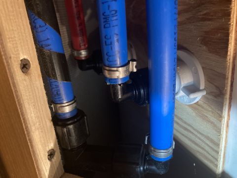 2015 Ford F-550 - Close-up view of plumbing pipes and fittings, with text visible on one of the blue pipes.