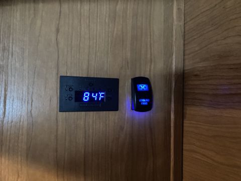 2015 Ford F-550 - A digital temperature gauge and a cooling fan switch are visible on a wooden surface.