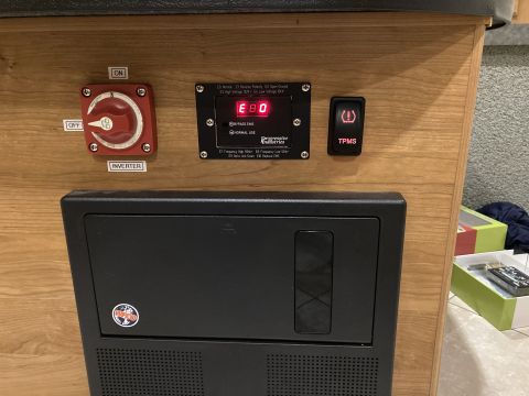 2015 Ford F-550 - Close-up of an RV's electrical control panel, showing an inverter switch and a TPMS indicator.