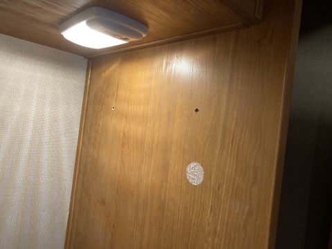 2015 Ford F-550 - Interior cabinet with overhead LED light and two small holes drilled into wood paneling. Supermotors.net logo visible.