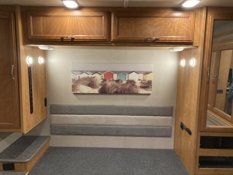2015 Ford F-550 - Interior view of an RV showing cabinetry, a bed area, and decorative artwork.