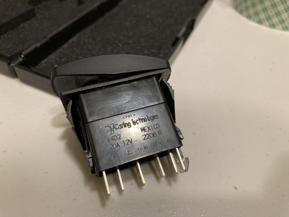 Black automotive switch with "Caring Technologies" and "20A 12V" markings