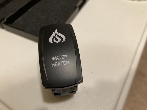 2015 Ford F-550 - A close-up view of a black switch labeled 'WATER HEATER' with a flame icon above it.