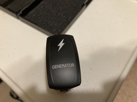 2015 Ford F-550 - A close-up view of a black toggle switch labeled 'GENERATOR' with a lightning bolt icon.