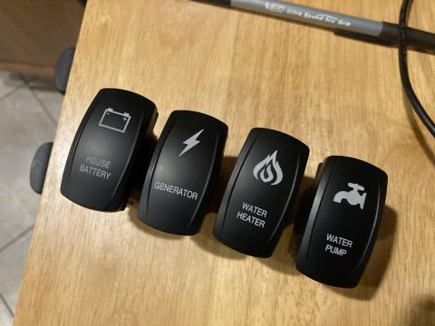 2015 Ford F-550 - Four accessory rocker switches are shown on a wooden surface.