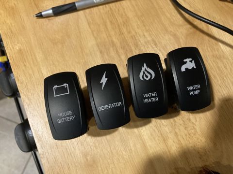 2015 Ford F-550 - Four aftermarket rocker switches for various vehicle functions are laid out on a wooden surface.