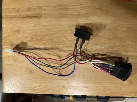 2015 Ford F-550 - A wiring harness with two switches and various colored wires is displayed on a wooden table.