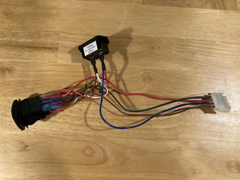 2015 Ford F-550 - A close-up view of a wiring harness with a switch and various colored wires, laid out on a wooden surface.