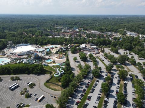 2015 Ford F-550 - An aerial view captures a bustling amusement park and water park complex, surrounded by dense forest and ample parking.