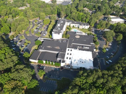 2015 Ford F-550 - An aerial perspective captures a commercial property dotted with vehicles and lush green trees.