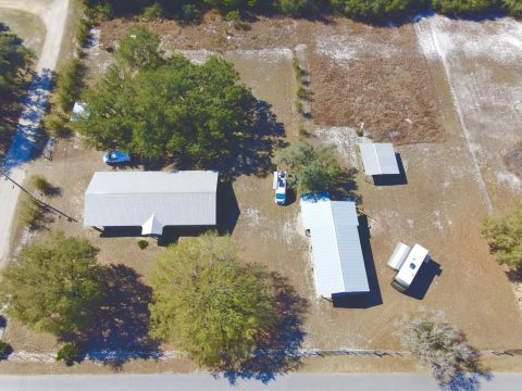 2015 Ford F-550 - Aerial view of a rural property with multiple structures and vehicles, including a white pickup truck.