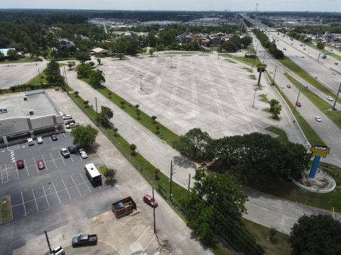 2015 Ford F-550 - An aerial perspective captures a vast, underutilized parking area adjacent to a multi-lane highway, with a distant amusement park visible.