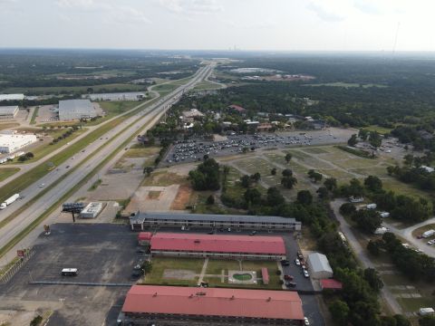 2015 Ford F-550 - An aerial perspective captures a highway stretching into the distance, bordered by commercial buildings and parking areas.