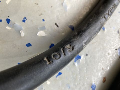 2015 Ford F-550 - Close-up of a black cable showing the embossed text '10/13', possibly indicating a manufacturing date.