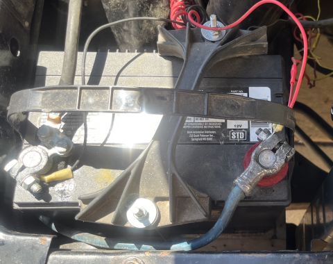 1975 Ford Ranchero - Close-up of a car battery with its connecting cables and terminals visible.