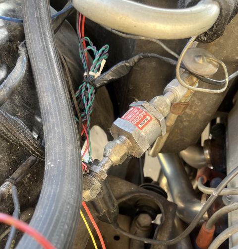 1975 Ford Ranchero - A close-up view of a fuel filter, part number A8200, is visible within the engine bay, surrounded by hoses and wiring.