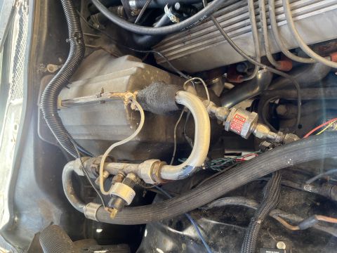 1975 Ford Ranchero - Engine bay detail showing various hoses, wiring, and a pressure switch or valve. No specific vehicle identified.