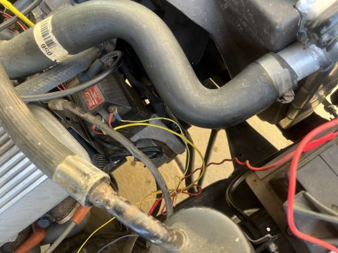 1975 Ford Ranchero - Close-up view of an engine bay, showing various hoses, wires, and a black electrical component.