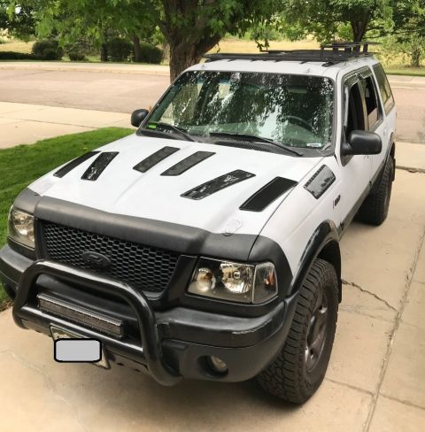 2000 Ford Explorer - White 2000 Ford Explorer SUV parked in a driveway with aftermarket modifications.