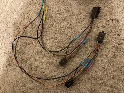 2015 Ford F-550 - A wiring harness with several spliced connections and black plastic connectors is visible on a textured surface.