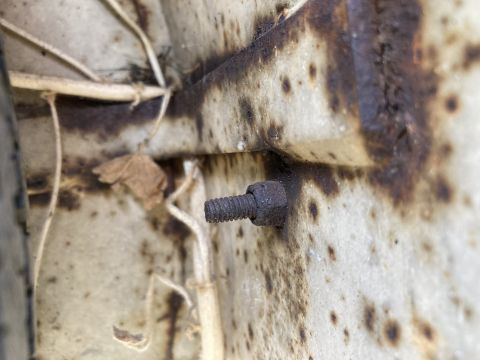 2015 Ford F-550 - A close-up view of a rusted bolt and surrounding corrosion on a vehicle's exterior panel.