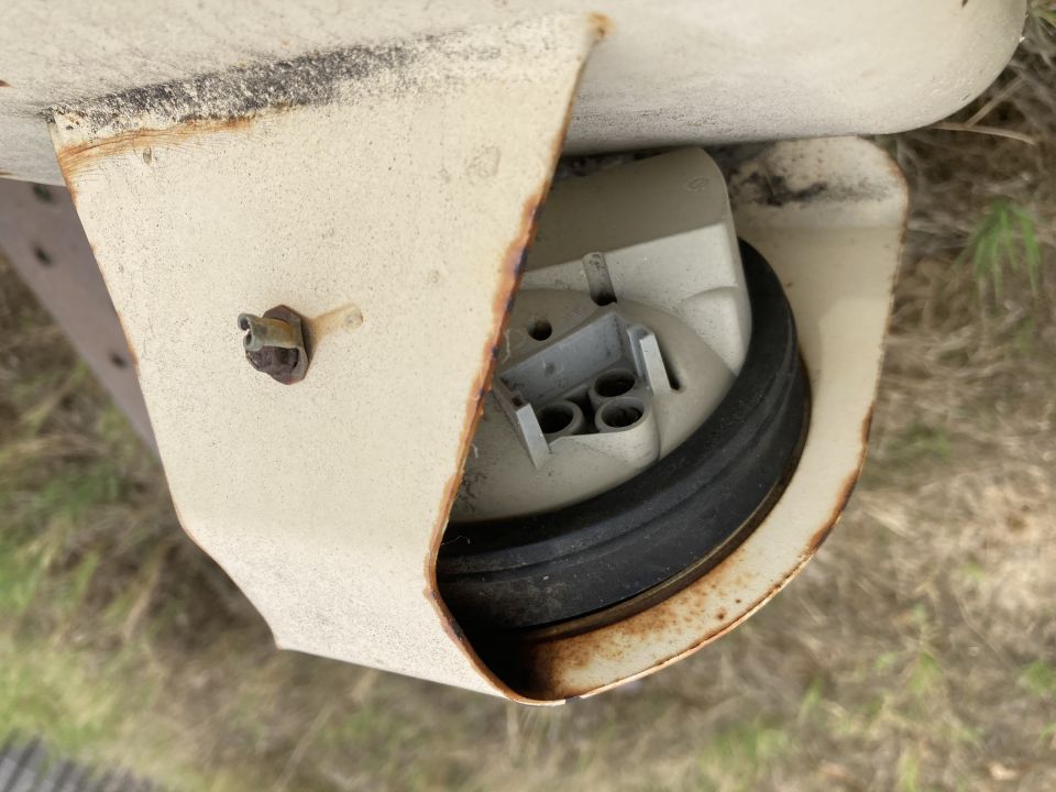 Taillight housing with rust and a black rubber seal, viewed from above