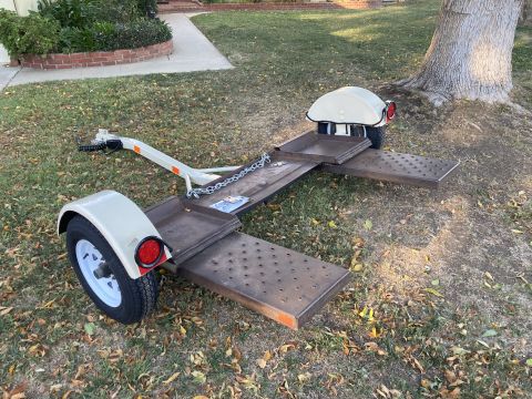 2015 Ford F-550 - This is a car trailer with a white tongue and fenders, sitting on a grassy area.