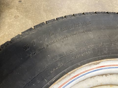 2015 Ford F-550 - Close-up of a cracked trailer tire with size ST175/80R13 visible.