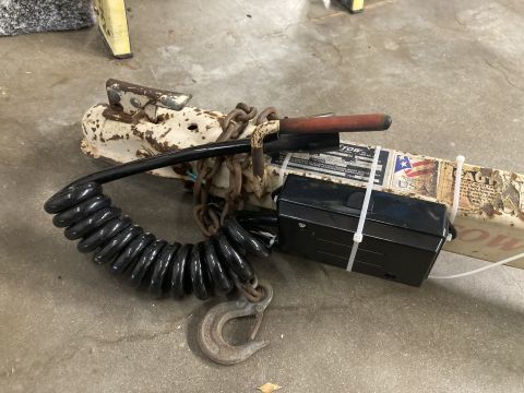 2015 Ford F-550 - Close-up of a trailer hitch assembly, showing its various components including chains and a coiled electrical cord.