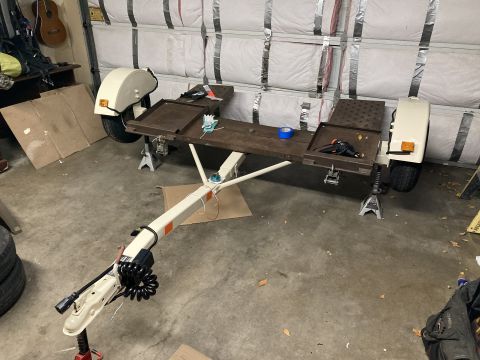 2015 Ford F-550 - A utility trailer is shown on jack stands inside a garage, with tools and tape on its deck.