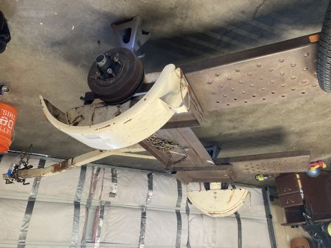 2015 Ford F-550 - A white bumper and brake drum assembly are supported by jack stands in a garage.