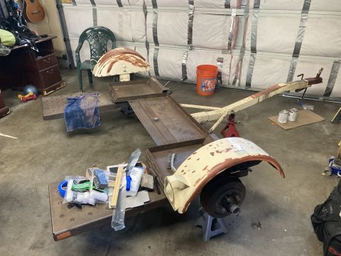 2015 Ford F-550 - Trailer frame and parts are laid out in a garage, possibly for restoration or repair.