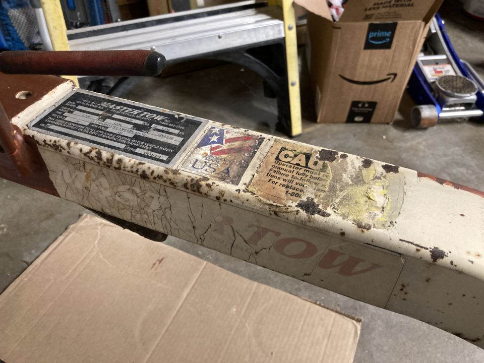 Close-up of a tow dolly with a 'MASTER TOW' label and caution stickers