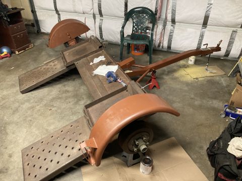 2015 Ford F-550 - Trailer frame and parts in a garage setting, possibly undergoing restoration or repair.