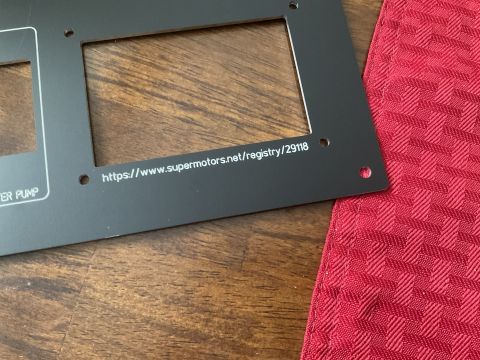 2015 Ford F-550 - A black panel with text and cutouts is shown on a wooden surface next to a red textured cloth.