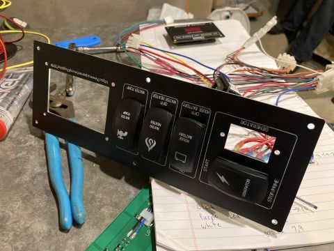 2015 Ford F-550 - A black monitor panel with various switches and labels for water pump, water heater, house battery, and generator is shown with wiring.
