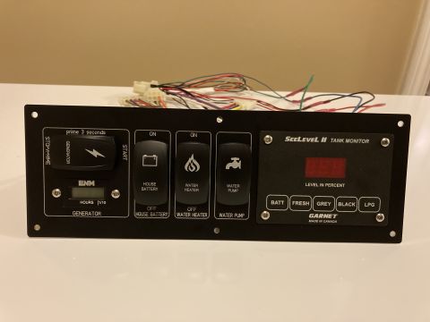 2015 Ford F-550 - This control panel features switches for generator, house battery, water heater, and water pump, along with a tank level monitor.
