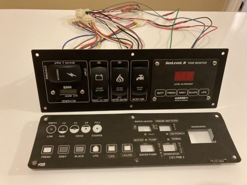 2015 Ford F-550 - Two black electronic panels with wiring, likely for an RV, are displayed on a white surface.