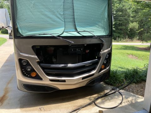 2015 Ford F-550 - The front of an RV is shown with the grille removed, revealing the radiator and engine components.