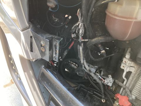 2015 Ford F-550 - The engine bay of a vehicle is visible, with focus on the complex wiring and fluid reservoir.