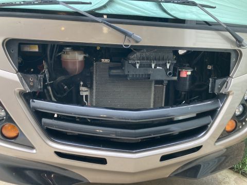 2015 Ford F-550 - RV front end with radiator and engine components exposed after grille removal.
