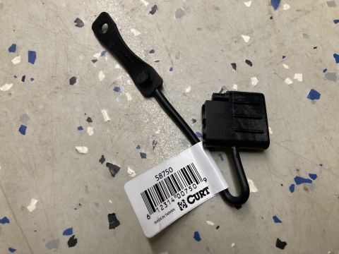 2015 Ford F-550 - A black towed harness part with a CURT brand label is shown on a speckled floor.