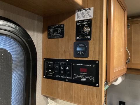 2015 Ford F-550 - Interior control panel for an RV, showing various system switches and a tank monitor display.